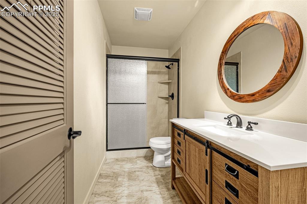 9890 Hardy Road Colorado Springs, CO 80908 - Photo 31 of 41 a bathroom with a sink a toilet and a mirror