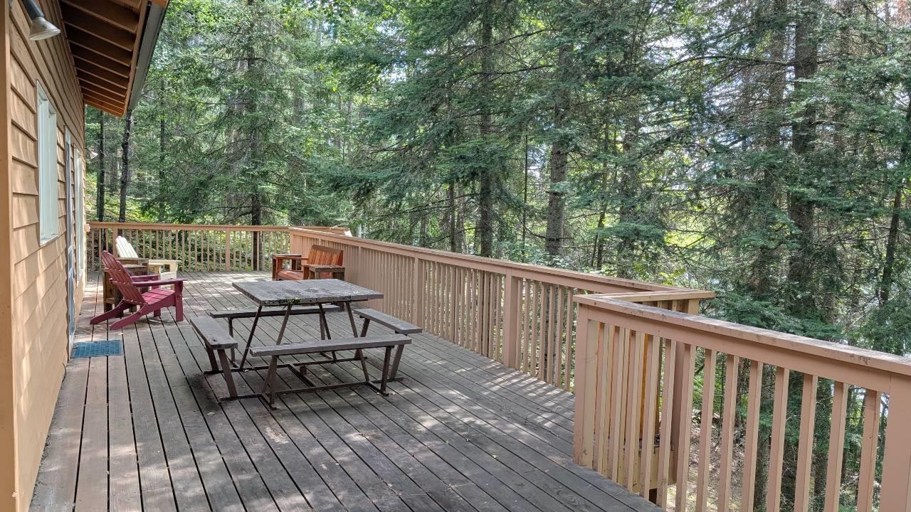 8884 Raps Road Cook, MN 55723 - Photo 33 of 46 Wooden terrace with outdoor dining space and view of wooded area