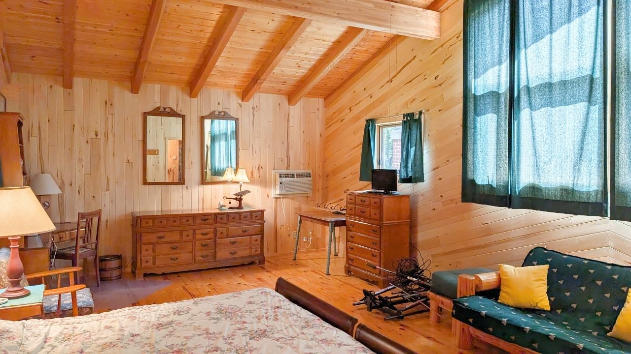 8884 Raps Road Cook, MN 55723 - Photo 8 of 46 Bedroom with wooden ceiling, wood-type flooring, wooden walls, and an AC wall unit