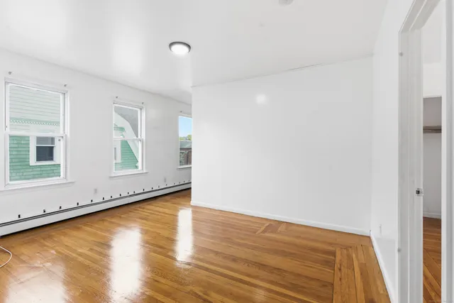 a view of a room with wooden floor and white walls