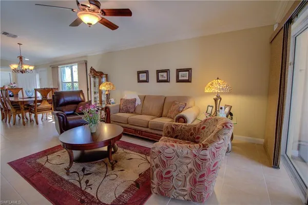 a living room with furniture a chandelier and a dining table