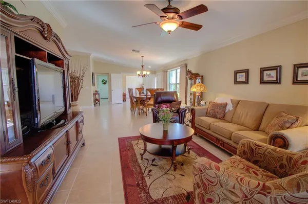 a living room with furniture a flat screen tv and kitchen view