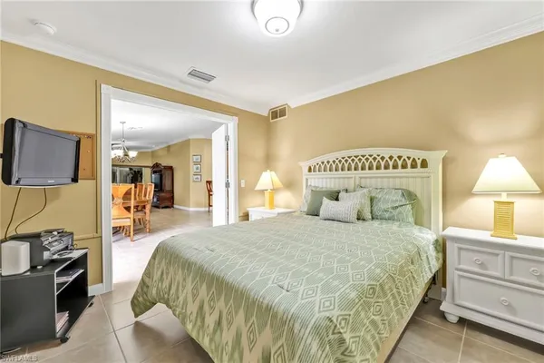 a bedroom with a bed a mirror on dresser and a table