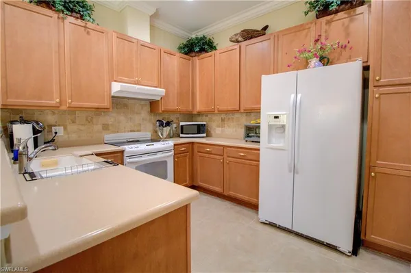 a kitchen with a sink a refrigerator and cabinets