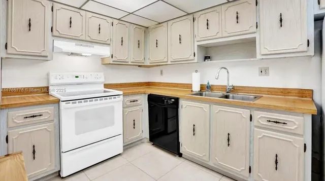 a kitchen with cabinets appliances and a refrigerator