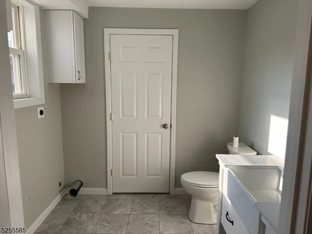 a bathroom with a toilet a sink and a window