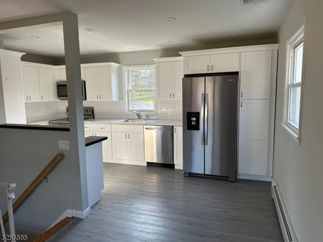a kitchen with a refrigerator a sink and cabinets