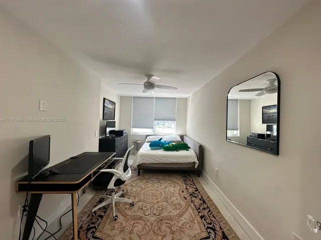 a bedroom with a large bed couch and a flat tv screen
