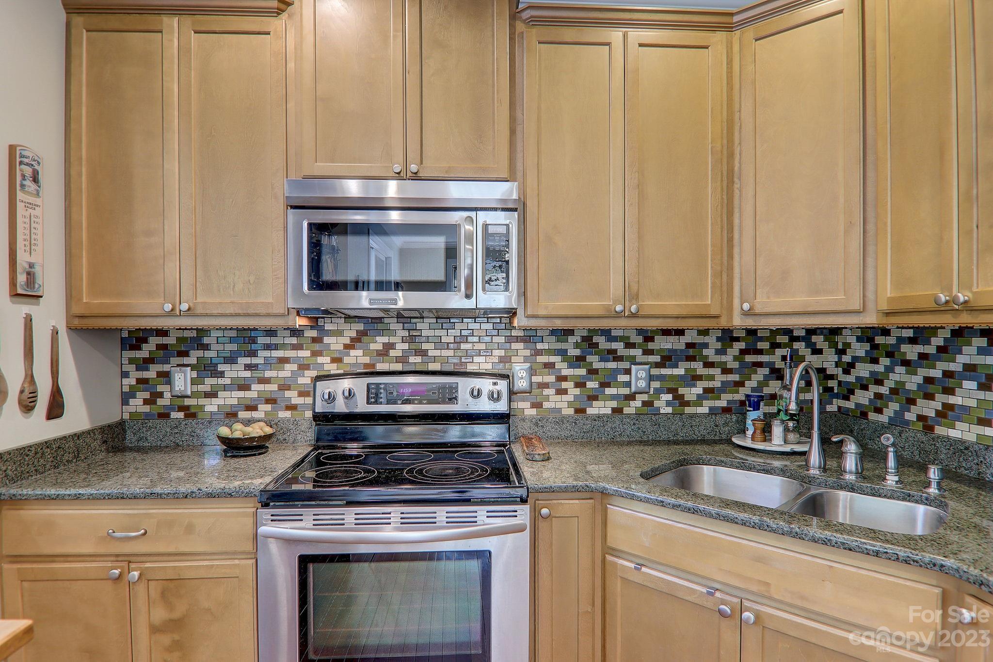 209 Whitaker Road Fairview, NC 28730 - Photo 13 of 44 a kitchen with granite countertop white cabinets and stainless steel appliances