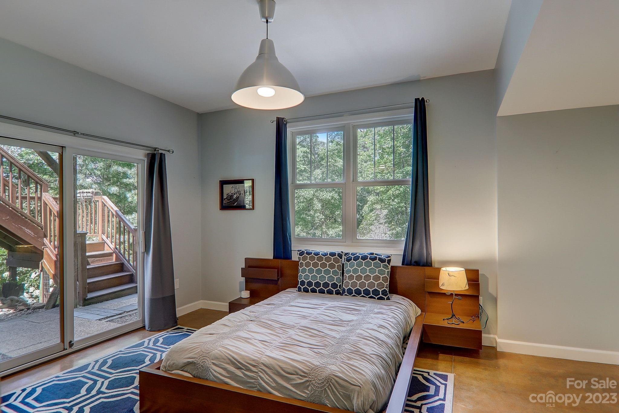 209 Whitaker Road Fairview, NC 28730 - Photo 23 of 44 a bedroom with a bed and large windows