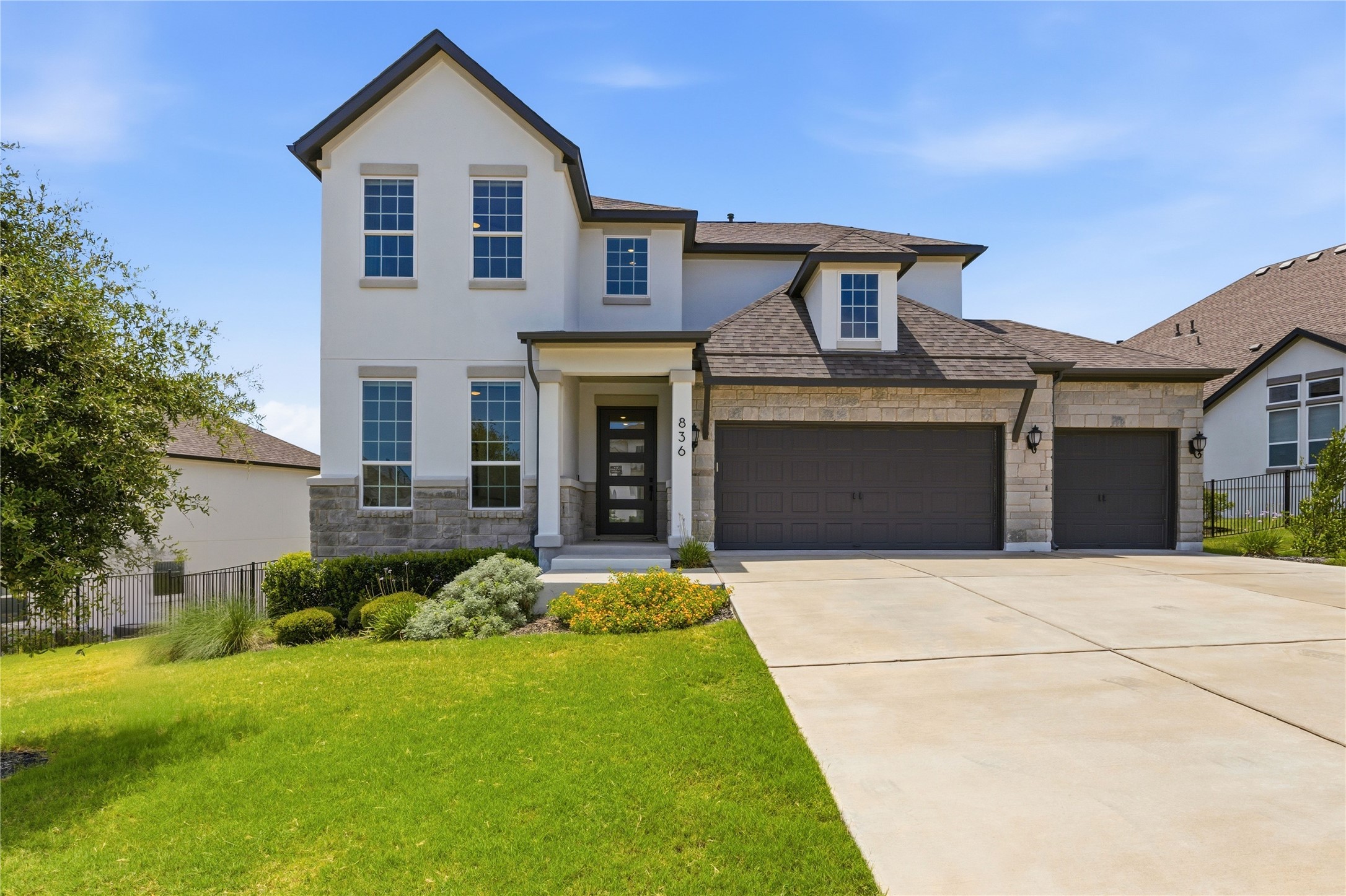 836 Villa Rialto View Leander, TX 78641 - Photo 2 of 33 Impressive curb appeal with a stone and stucco facade, featuring an attached double garage and manicured lawn.