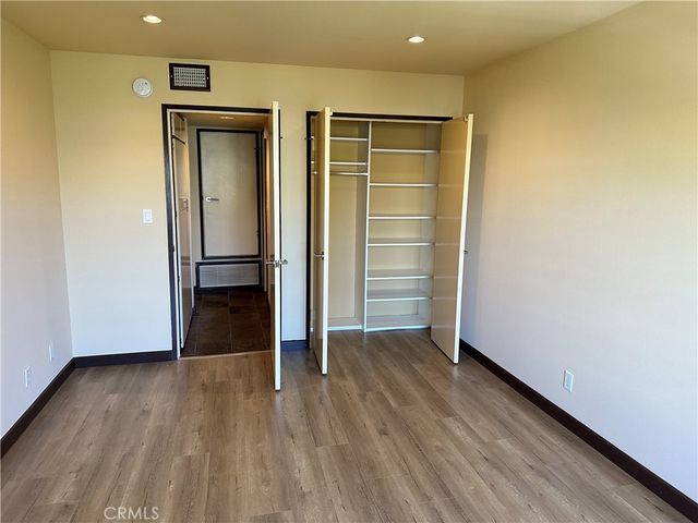 an empty room with wooden floor and closet