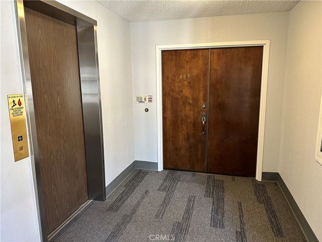 an empty room with wooden floor and entrance