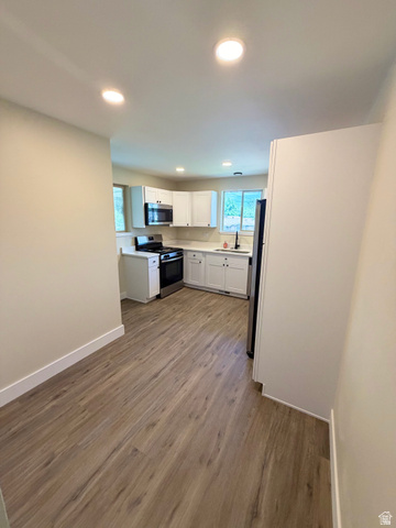 450 13800 South, Unit 2 Draper, UT 84020 - Photo 4 of 21 Modern kitchen featuring white cabinetry, stainless steel appliances, and wood-finish flooring
