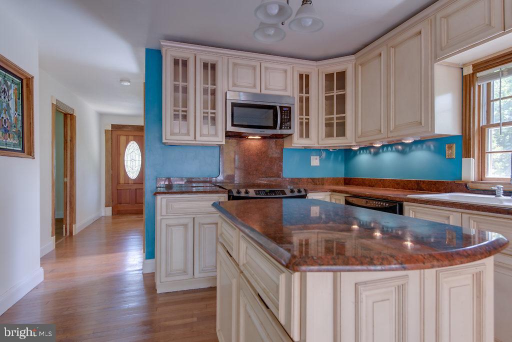 740 Powhatan Beach Road Pasadena, MD 21122 - Photo 14 of 39 Tall cabinets, hardwood floor and island