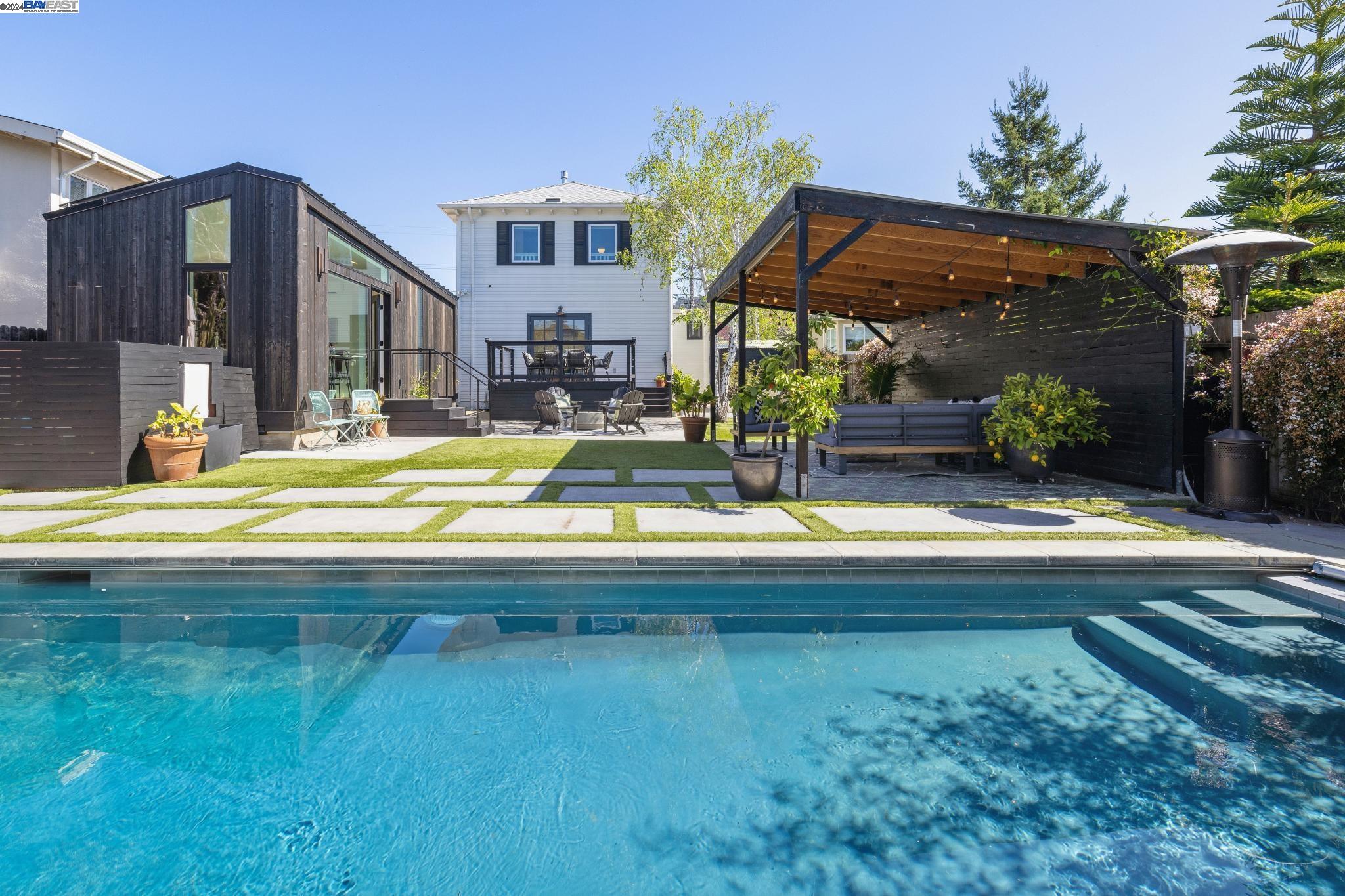 a view of swimming pool in the backyard of house along with outdoor seating