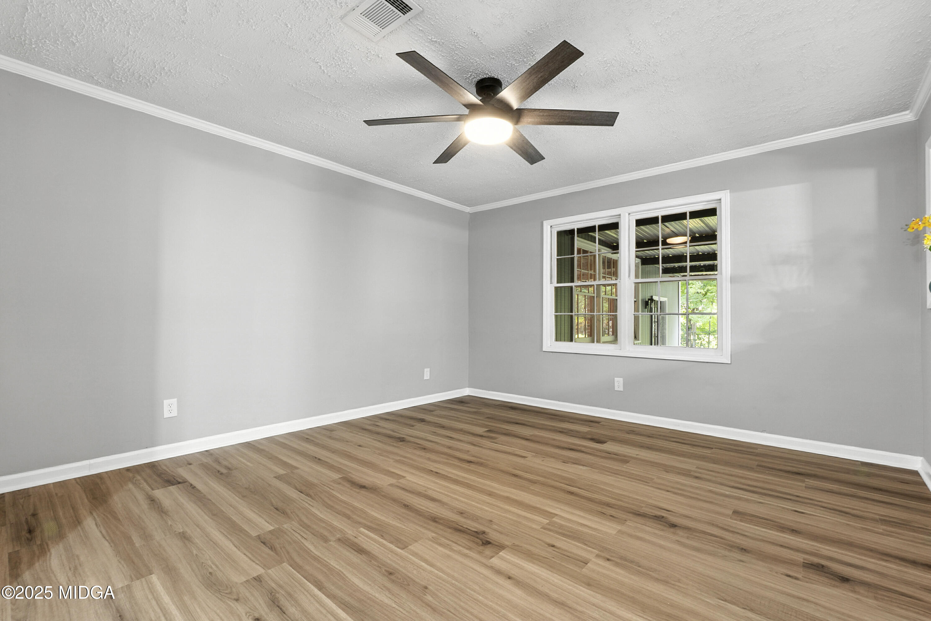 109 Scarborough Road Centerville, GA 31028 - Photo 5 of 52 an empty room with wooden floor ceiling fan and windows