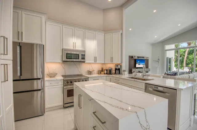 a kitchen with stainless steel appliances granite countertop a refrigerator sink and stove
