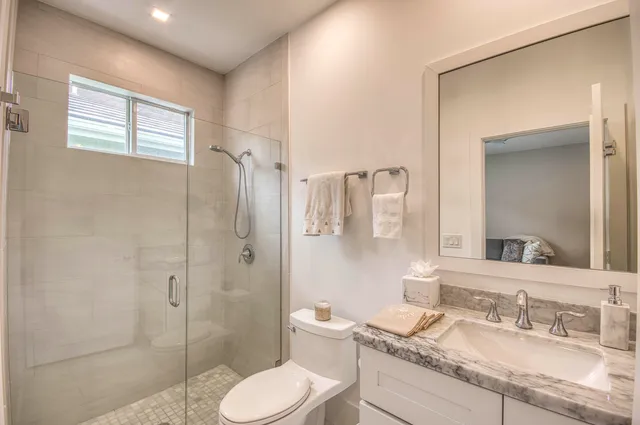 a bathroom with a granite countertop sink toilet and shower
