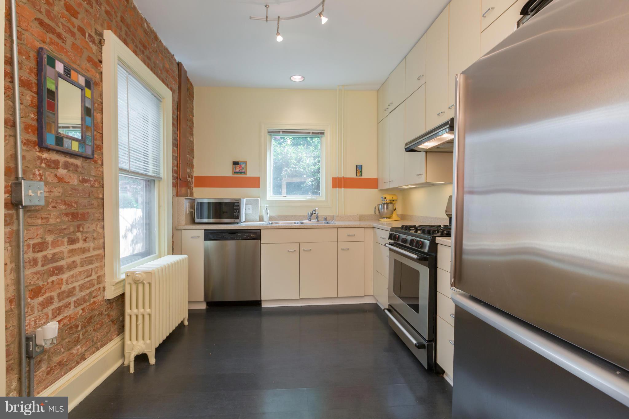 1450 T Street Northwest Washington, DC 20009 - Photo 5 of 14 a kitchen with white cabinets and white appliances