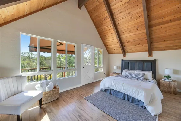 a bedroom with a bed and a large window with outer view