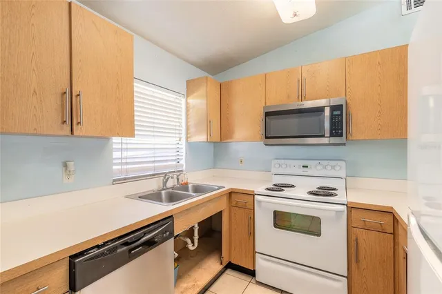 a kitchen with a sink stove top oven and microwave