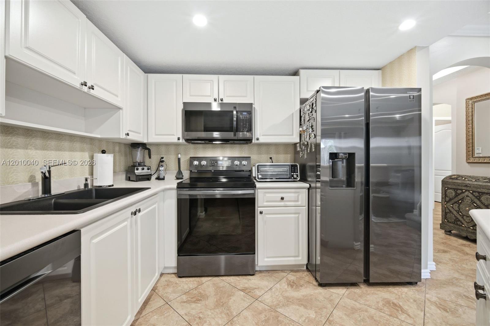 12978 Southwest 29th Court Miramar, FL 33027 - Photo 8 of 32 a kitchen with a refrigerator sink and microwave