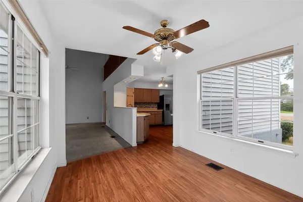 a view of a livingroom with wooden floor and a ceiling fan