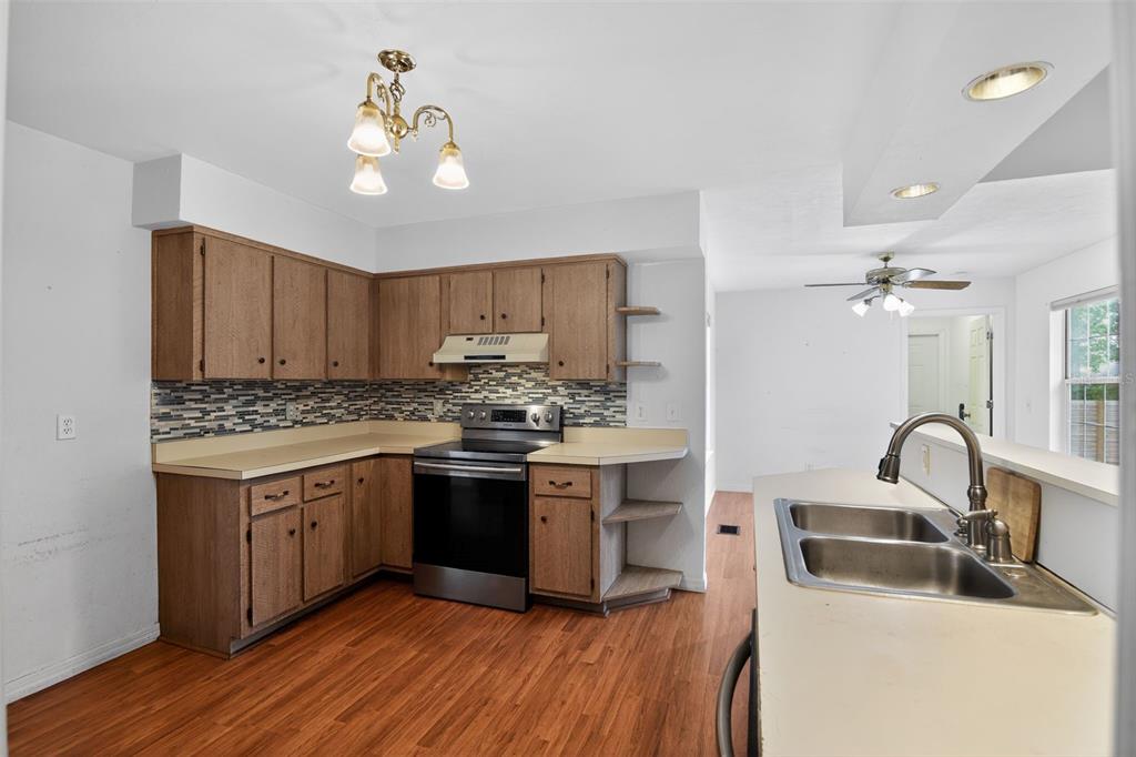4553 Southeast 14th Street Ocala, FL 34471 - Photo 15 of 28 a kitchen with stainless steel appliances granite countertop a sink stove and refrigerator