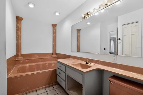 a bathroom with a tub sink and mirror