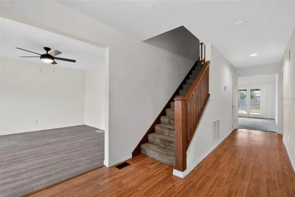 a view of a hallway with wooden floor and staircase