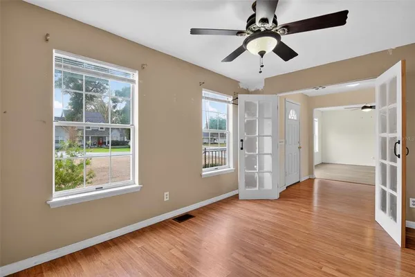 a view of an empty room with wooden floor and a window