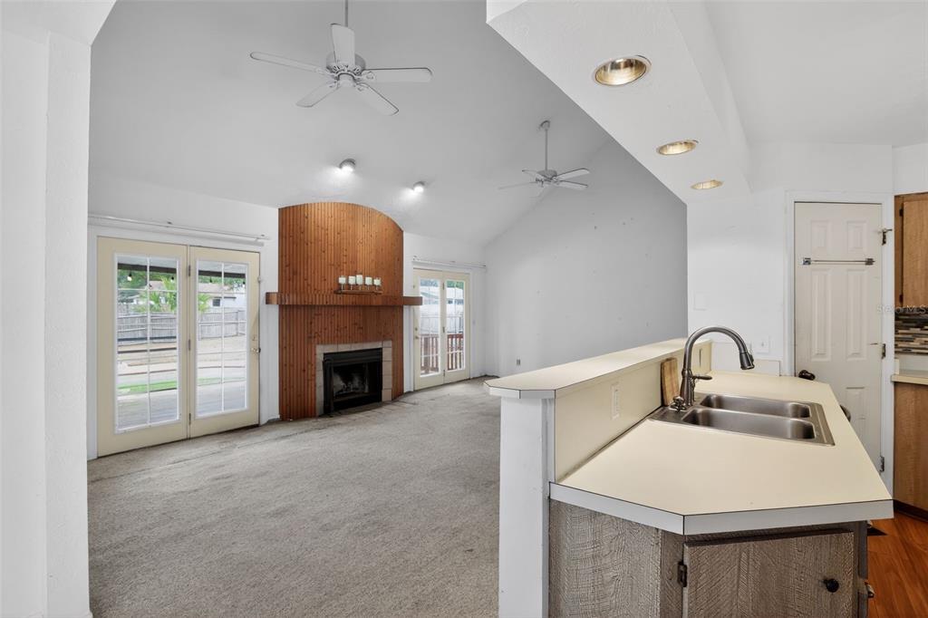 4553 Southeast 14th Street Ocala, FL 34471 - Photo 8 of 28 a kitchen with a sink a fireplace and a chandelier