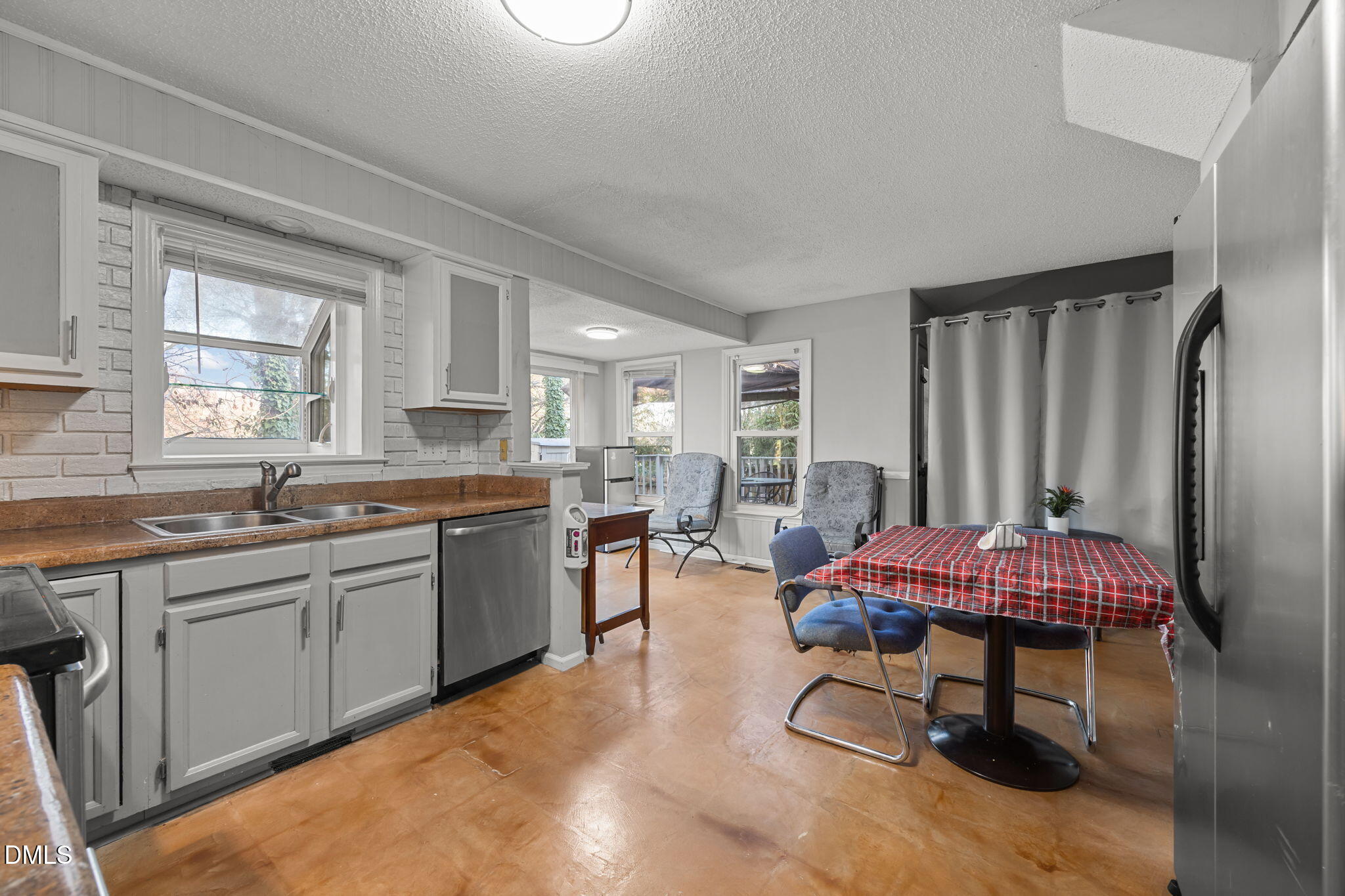 4700 Tolley Court Raleigh, NC 27616 - Photo 16 of 38 a kitchen with a sink dining table and chairs