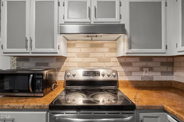 a stove top oven sitting inside of a kitchen
