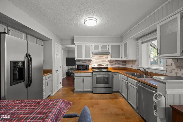 a kitchen with stainless steel appliances granite countertop a refrigerator sink and stove