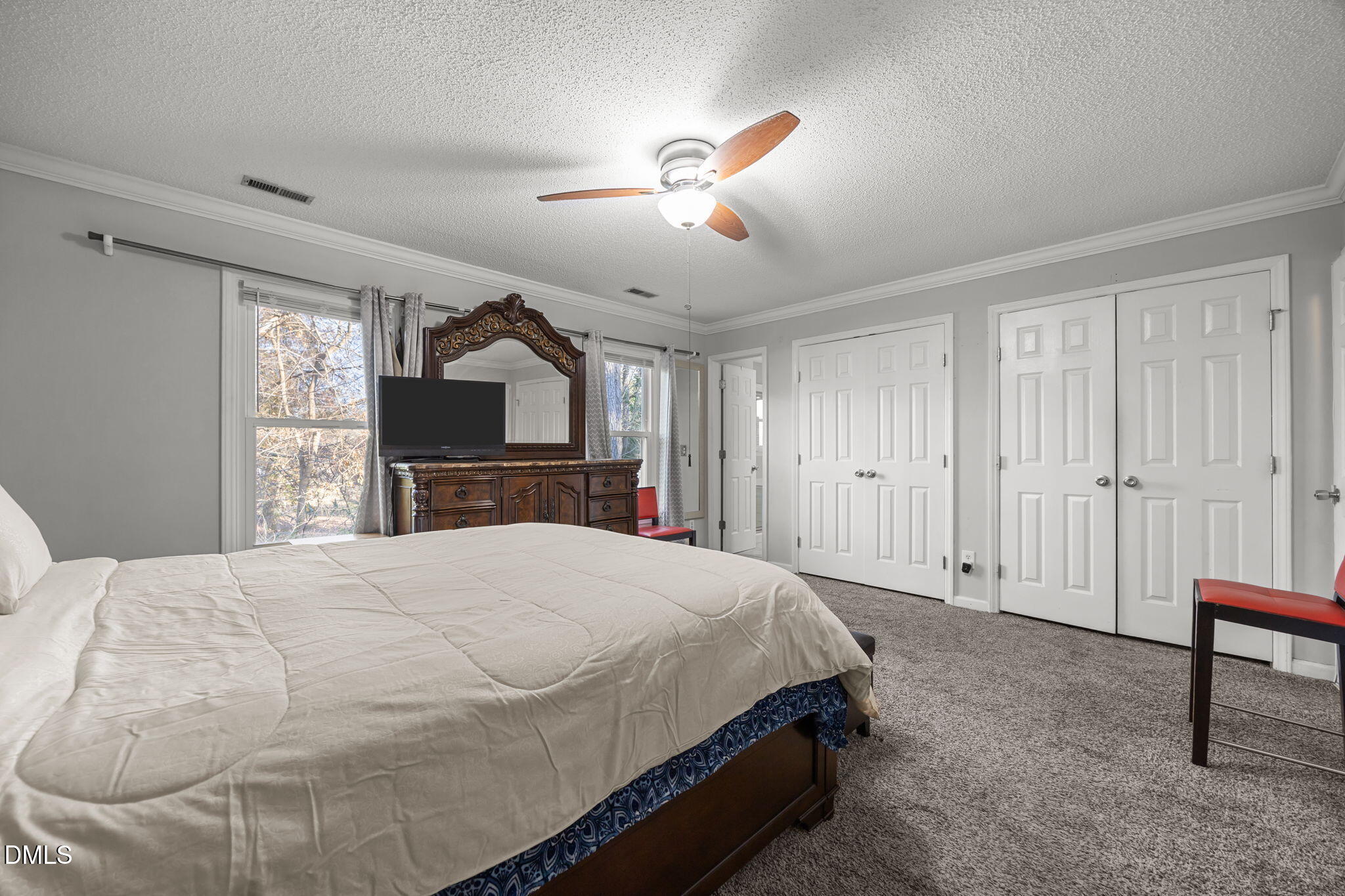 4700 Tolley Court Raleigh, NC 27616 - Photo 30 of 38 a spacious bedroom with a bed and a dresser with mirror