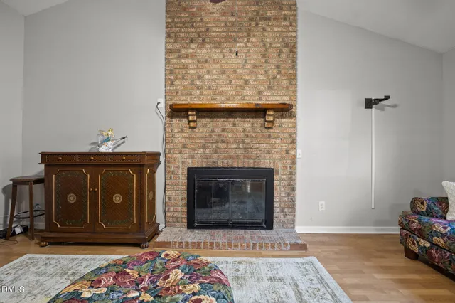 a living room with a fireplace wooden floor and a fireplace