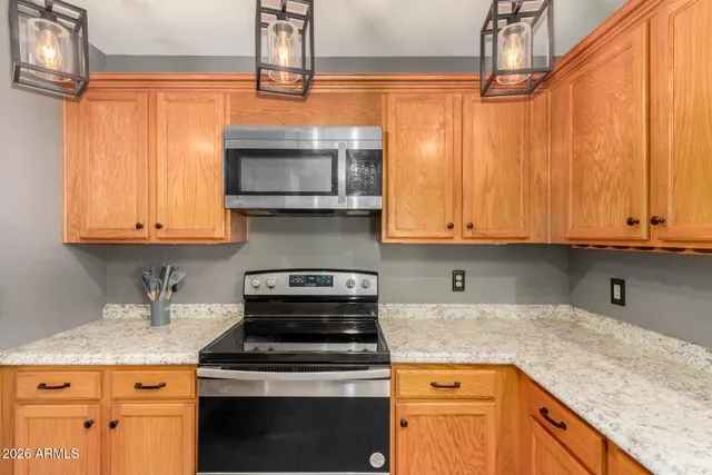 a kitchen with stainless steel appliances granite countertop a stove a sink and a microwave