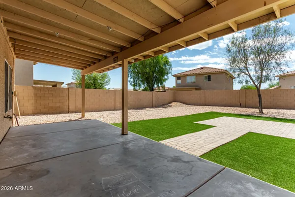 a yellow house with a yard and large trees