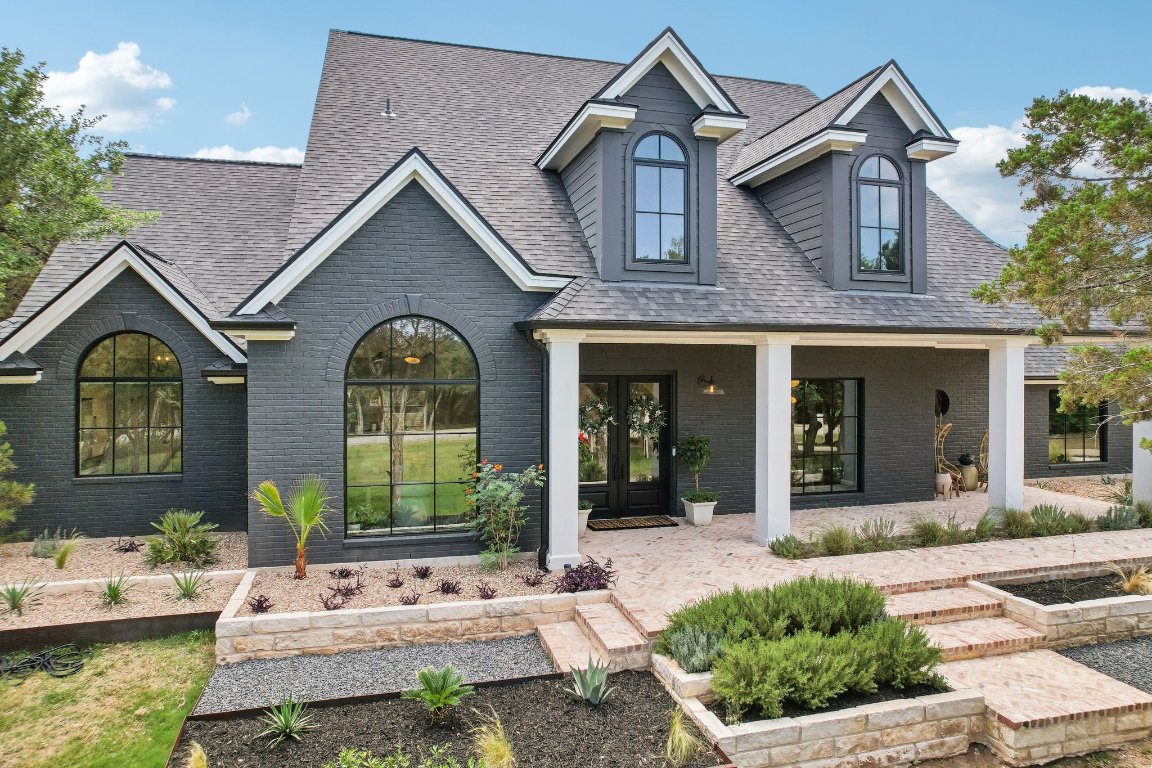 a view of house with a big yard and potted plants