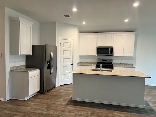 a kitchen with kitchen island a refrigerator stove and microwave