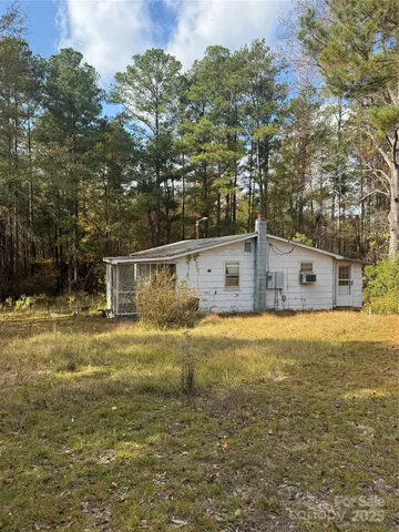 a front view of house with yard and trees in the background