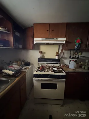 a white stove top oven sitting inside of a kitchen