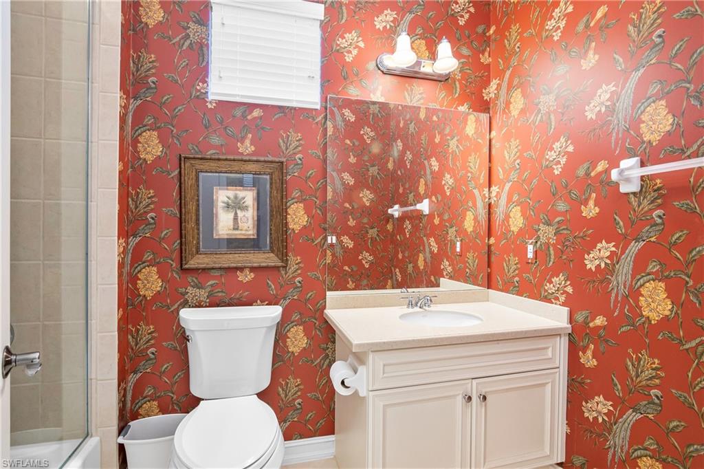 1349 Serrano Circle Naples, FL 34105 - Photo 11 of 37 a bathroom with a sink a toilet and a mirror