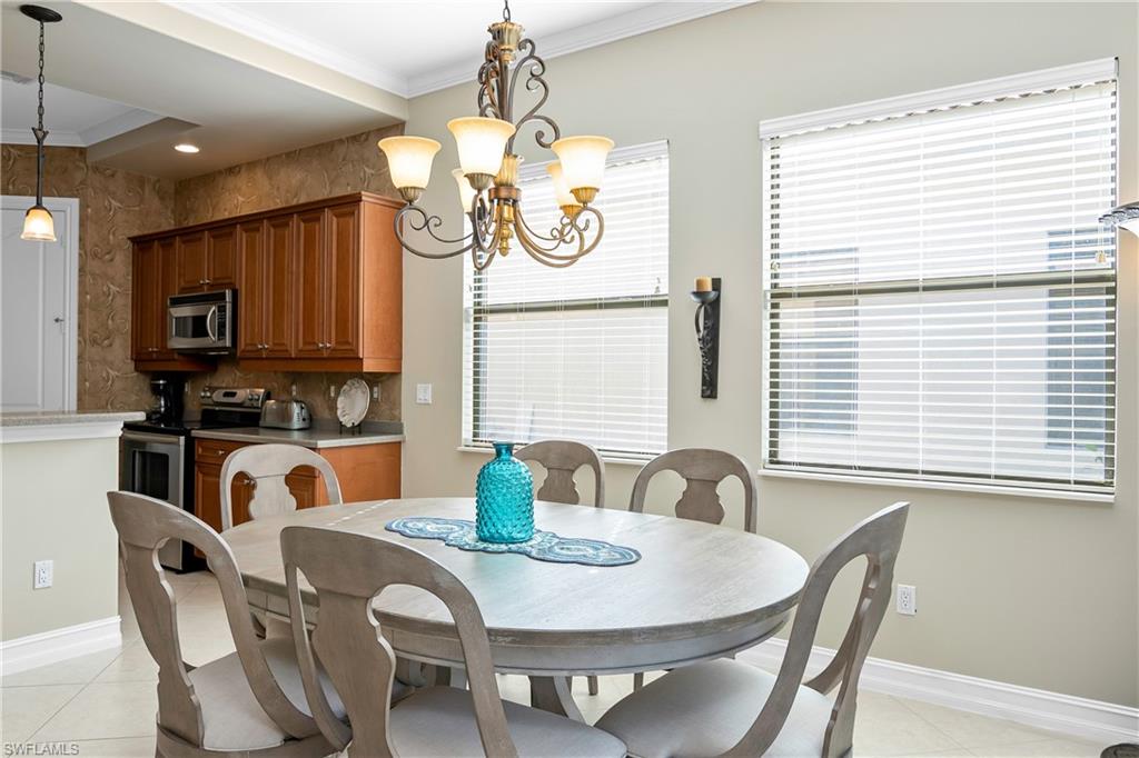 1349 Serrano Circle Naples, FL 34105 - Photo 16 of 37 a view of a dining room with furniture and chandelier