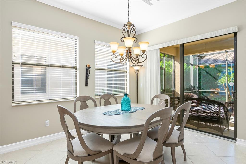 1349 Serrano Circle Naples, FL 34105 - Photo 17 of 37 a view of a dining room with furniture large windows and wooden floor