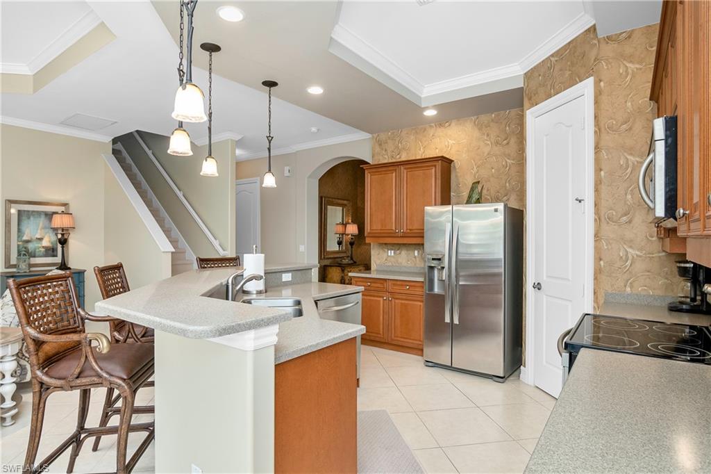 1349 Serrano Circle Naples, FL 34105 - Photo 20 of 37 a kitchen with stainless steel appliances kitchen island granite countertop a refrigerator a sink a stove and island