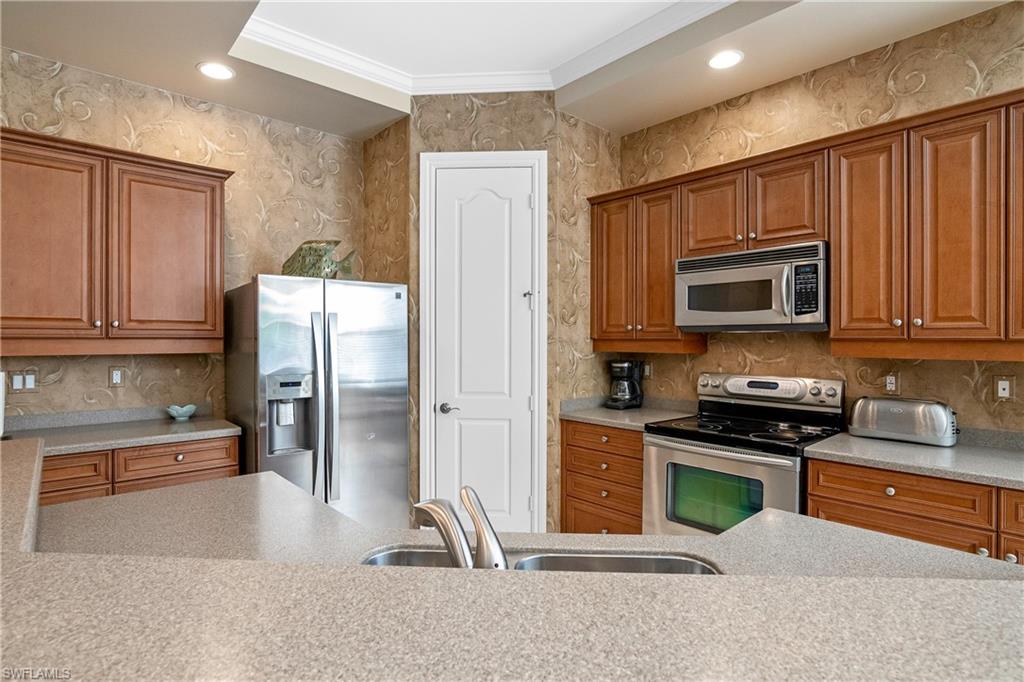 1349 Serrano Circle Naples, FL 34105 - Photo 21 of 37 a kitchen with stainless steel appliances granite countertop a refrigerator and a stove top oven
