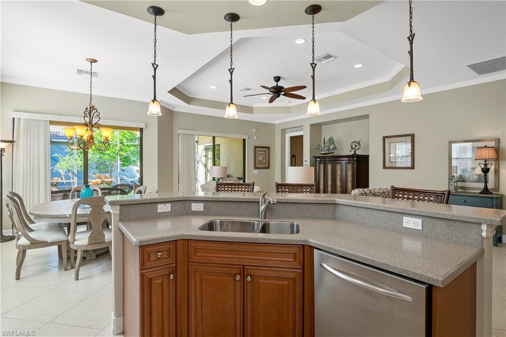 1349 Serrano Circle Naples, FL 34105 - Photo 22 of 37 a kitchen with a counter a sink and living room view